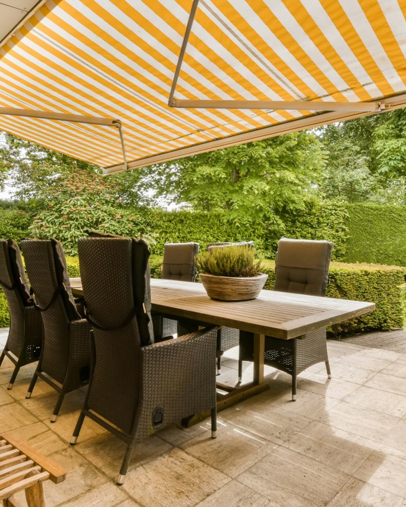 a patio with a table and chairs under an umbrella