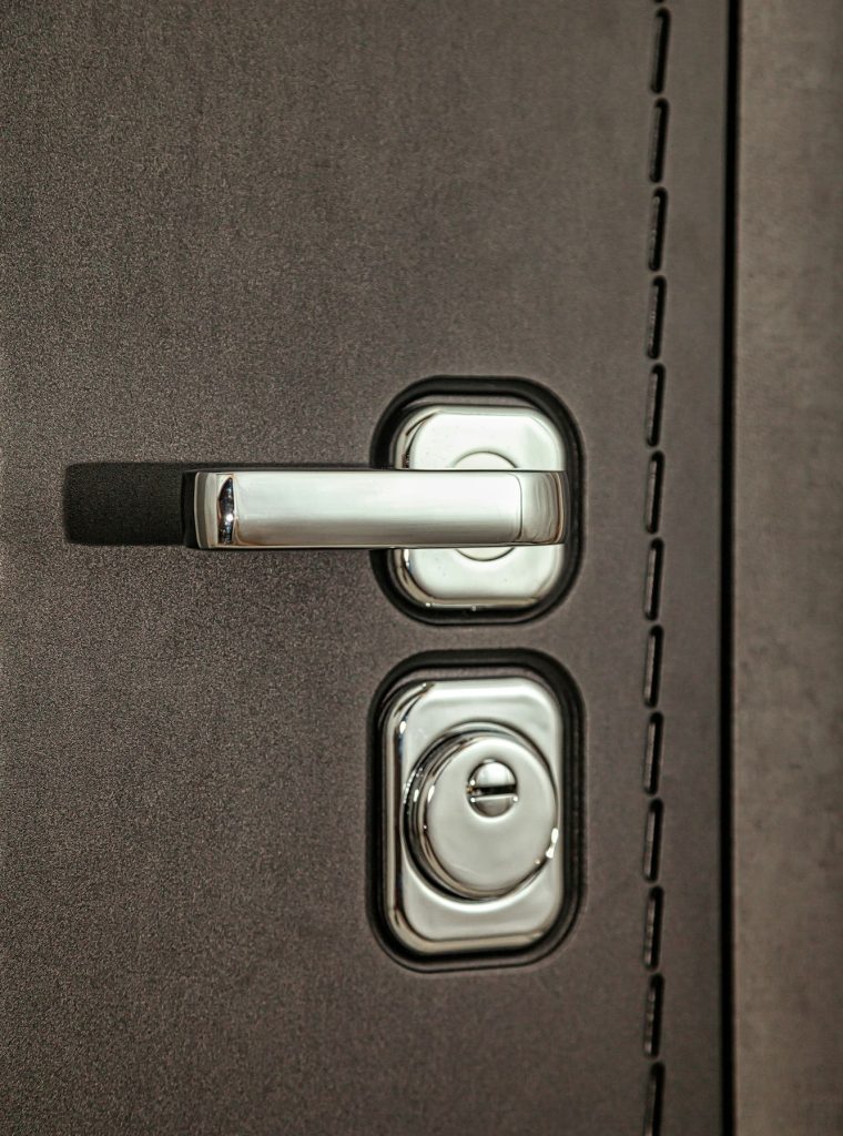 Close-up metal handle armor door and door lock on white background